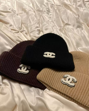 Cappello Chanel beige con logo nero e ricami bianchi