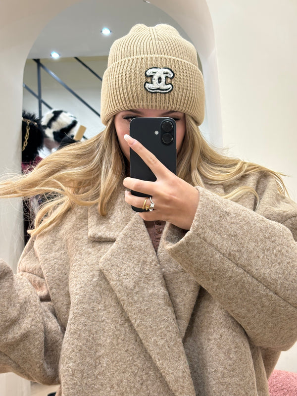 Cappello Chanel beige con logo nero e ricami bianchi