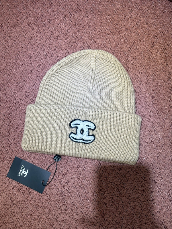 Cappello Chanel beige con logo nero e ricami bianchi