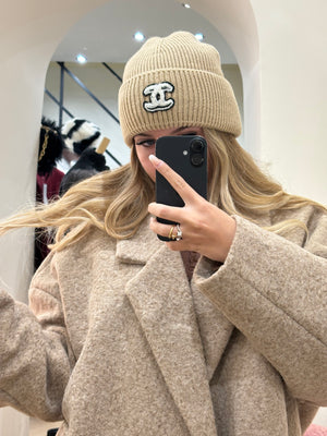 Cappello Chanel beige con logo nero e ricami bianchi